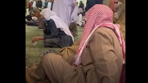 شاهد.. شيخ سعودي يغطي باكستانيا في المسجد النبوي بردائه