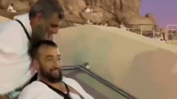 شاهد.. حاج بساق واحدة يدفع صديقه على كرسي متحرك